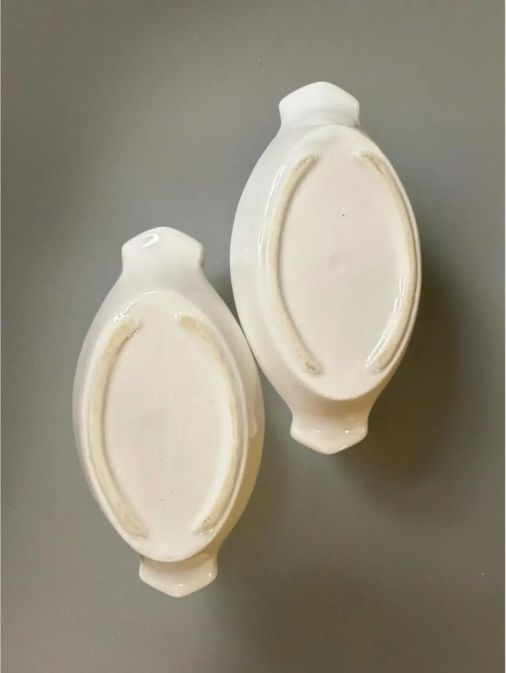 White ceramic oval au gratin dish with red apple and green leaf decoration.